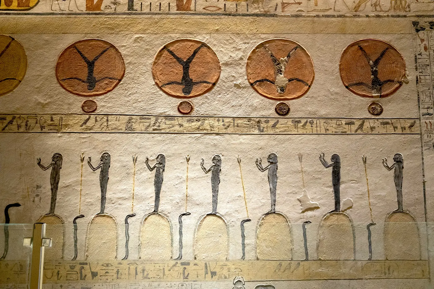 Painted wall scenes and hieroglyphic funerary texts inside a rock-cut tomb in the Valley of the Kings